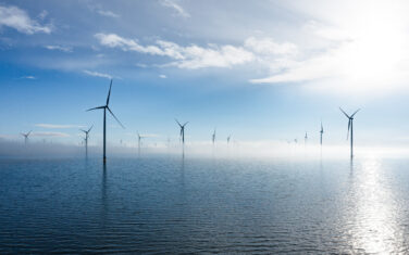 Windmill farm in the lake Ijsselmeer with fog.