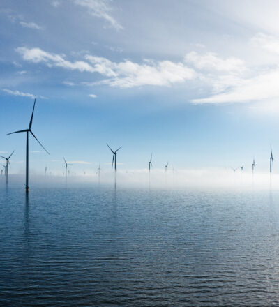 Windmill farm in the lake Ijsselmeer with fog.